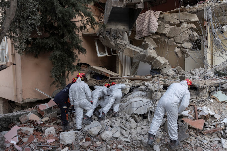 A search team look through the cracks in the rubble of a house as they look for missing persons Leyla Habip and Nejat Habip in the aftermath of the deadly earthquake, in Hatay, Turkey, February 18, 2023.