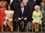 Britain's Queen Elizabeth, Prince Harry and Meghan, the Duchess of Sussex, pose for a picture in London, Britain, on June 26 2018. 