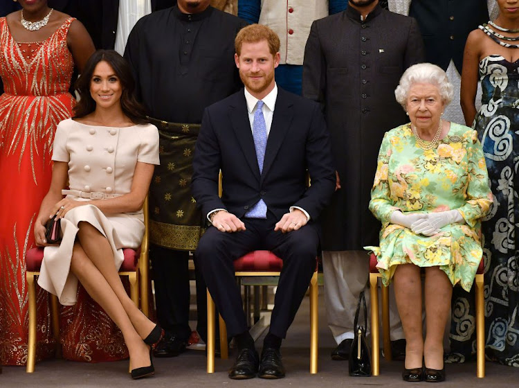 Britain's Queen Elizabeth, Prince Harry and Meghan, the Duchess of Sussex, pose for a picture in London on June 26 2018. The Queen has responded to allegations made by the pair in an interview with Oprah Winfrey.