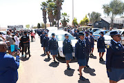 SAPS walk alongide the hearse carrying warrant officer Dalmain Morris.