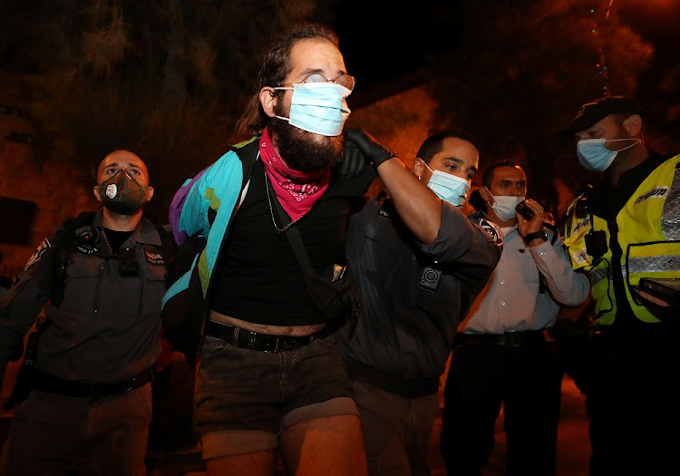 A man is detained as protesters demonstrate against Israeli Prime Minister Benjamin Netanyahu's alleged corruption and his handling of the coronavirus disease (COVID-19) crisis, amid a second-wave national coronavirus lockdown, in Jerusalem October 18 2020.