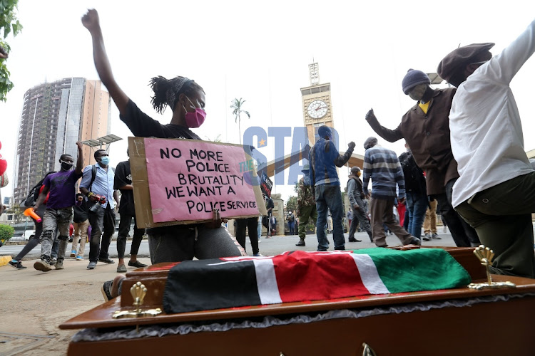 Youths carrying a coffin demonstrate outside Parliament on June 9, 2020.