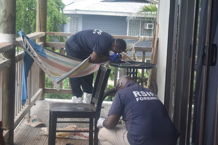 Forensic officers work at the site of a blast which killed two men who worked for an aid agency that helps to dispose of unexploded bombs in West Honiara, Solomon Islands, at the weekend.