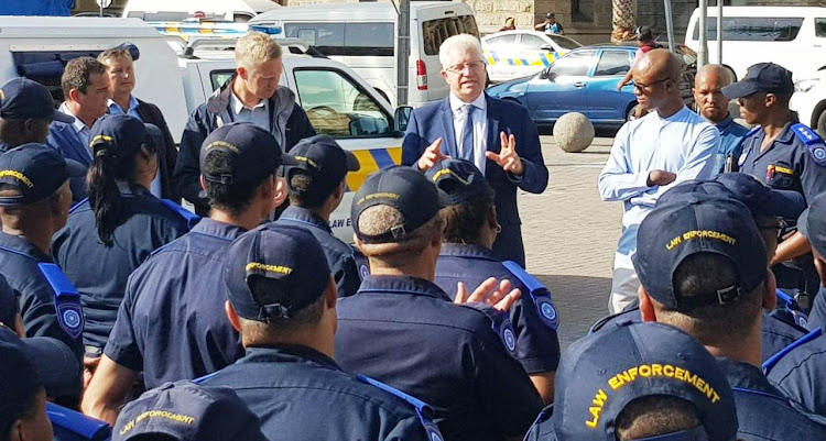 Alan Winde, accompanied by DA chief whip John Steenhuisen, left, and City of Cape Town mayoral committee member for safety and security JP Smith, meets members of Cape Town's rail enforcement unit on the Grand Parade on January 29 2019.