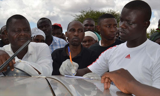 Benard Musyoki (centre) speaks to the police who had come to collect his wife's body. /MUSEMBI NZENGU