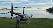 Essie Esterhuysen with his helicopter at its landing spot on the shore of the Vaal Marina.