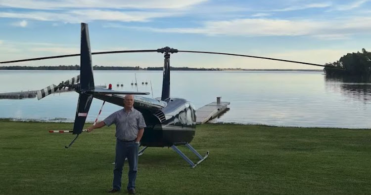 Essie Esterhuysen with his helicopter at its landing spot on the shore of the Vaal Marina.