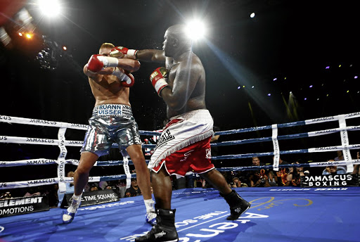 Elvis Moyo, of Zimbabwe, lands a punch on Ruann Visser, of SA, during their heavyweight bout at Sun Arena Time Square.