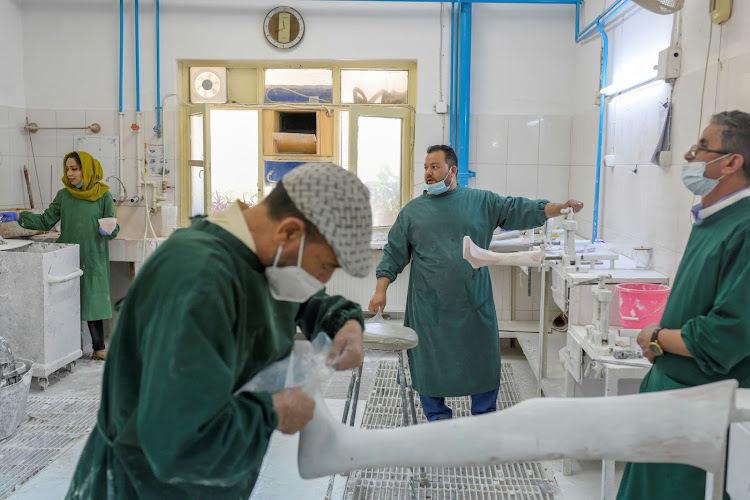 In this photograph taken on October 11, 2021, technicians work on prosthetic limbs at the International Committee of Red Cross Rehabilitation Centre in Kabul.