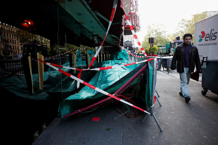 Sails of the landmark red windmill atop the Moulin Rouge are seen covered on the ground on April 25, 2024, after they fell during the night.