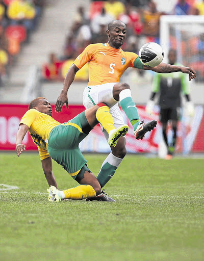 CAPTAINS COURAGEOUS: Bafana skipper Katlego Mphela, left, fights for possession with Didier Zokora, his opposite number in the Ivory Coast team, during yesterday's Nelson Mandela Challenge in Port Elizabeth Picture: THEMBINKOSI DWAYISA