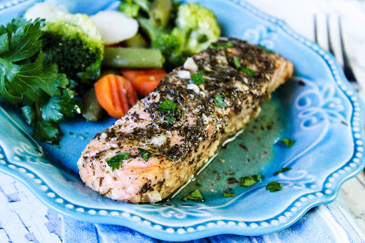 A piece of Easy Baked Salmon on a plate with veggies.