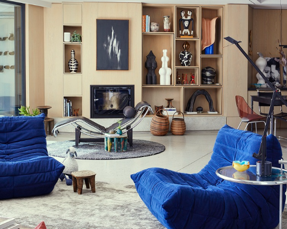 The oak cabinetry in the living/dining room warms the space and is custom-designed to accommodate handpicked ceramic works. The blackand-white ceramic piece is by Martine Jackson, the artwork above the fireplace is by Alexandra Karakashian, the wooden figurine is by Norman Catherine and the marbled ceramic is by Patsy Groll.