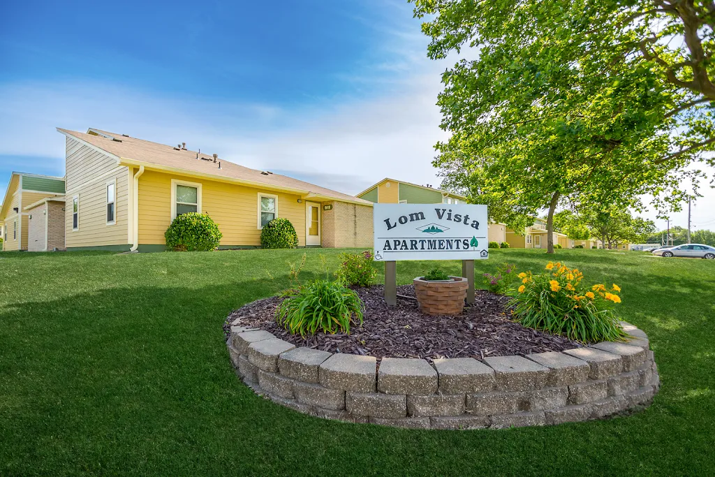 Lom Vista Apartment outdoor sign with stone wall and landscaping