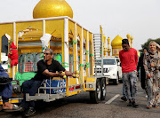 A man giving apples to people during a procession to mark the Muslim holy day of Ashura in Durban. 