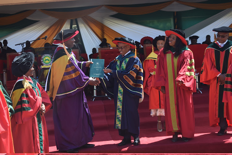 Safaricom CEO Peter Ndegwa receives Meru university of Science and Technology Charter from from his predecessor Equity CEO James Mwangi.