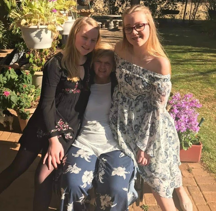 Jillian-Joan van der Merwe with her daughters Jodi, left, and Kerry-Leigh at their home in Bloemfontein. The single mom was left paralysed after a horrific car crash caused by a poorly maintained Free State road.