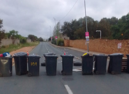 Northriding residents blocked a road with rubbish bins to protest about electricity outages.