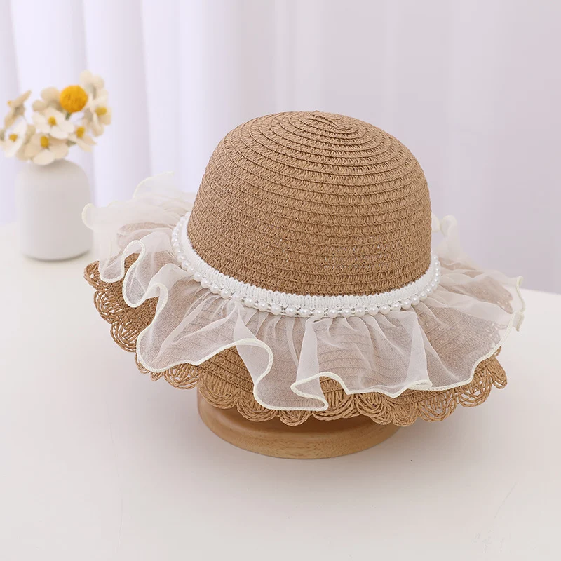 Kinder zonnehoed van stro met kant en parels, beschermt tegen de zon met stijl, ideaal voor vakantie en strand.
