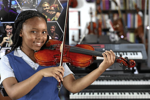 Mbali Phato after receiving a violin from Anthony Franklin of Lovemore Music. The instrument was donated by a Czech violin maker after it was built by three boys in his workshop. /ANTONIO mUCHAVE