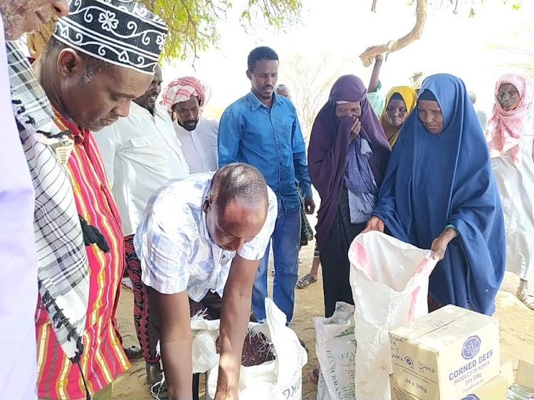 Bura East deputy county commissioner Thomas Bett leads food distribution exercise in Nanigi on Wednesday.