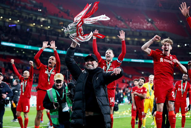 Liverpool manager Juergen Klopp celebrates with the trophy and his players after winning the League Cup final against Chelsea at Wembley in London on Sunday.