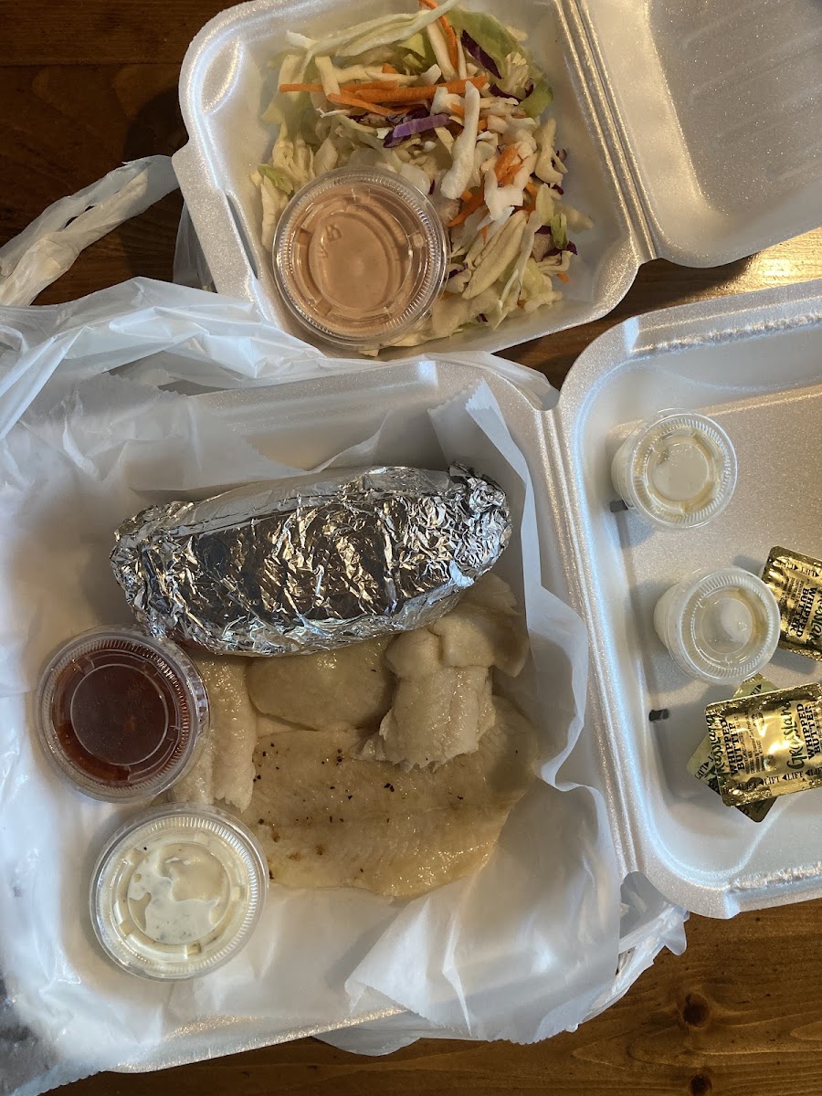 Broiled fish, baked potatoe, and slaw to-go.