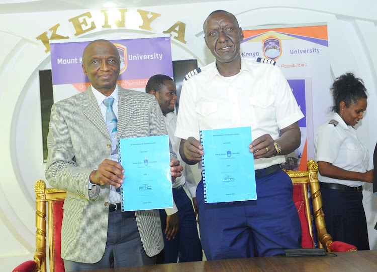 Mount Kenya University Vice-chancellor, Prof Deogratius Jaganyi.{left} with Flight Training Centre, Chief Executive Officer , Captain Godwin Wachira {Right] exchanging documents of MOU . Mount Kenya University entered into a partnership with the Flight Training Center that will enable student pilots to enroll for other courses that will expand their world view.