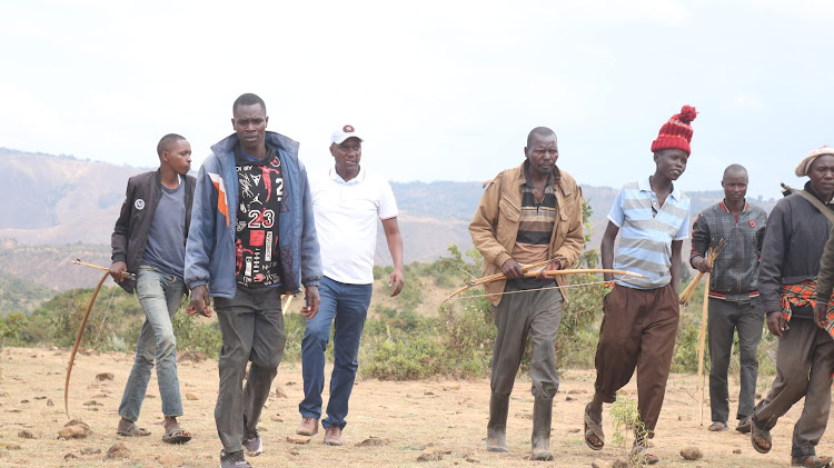 Residents armed with bows and arrows patrol volatile Mochongoi, Baringo South, on Tuesday.