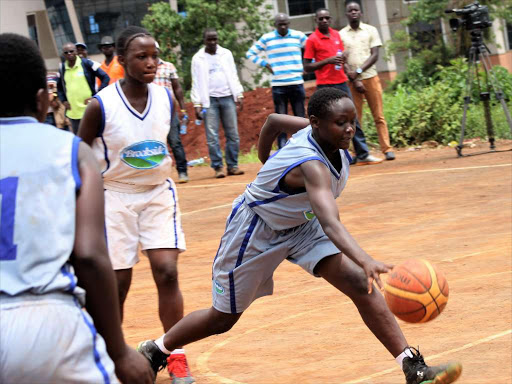 Butere's Mary Lisa dribbles the ball as Kaya Tiwi's Irene Onyango looks on in their past match