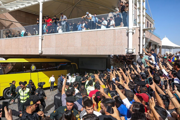 Iranian supporters of Al-Nassr star Cristiano Ronaldo cheer next to his club's bus in front of their hotel in Tehran on Monday. Al-Nassr meet FC Persepolis on Tuesday in their AFC Champions League group E match. Due to the crowd gathered around the Al-Nassr hotel, the canceled its training in Tehran.