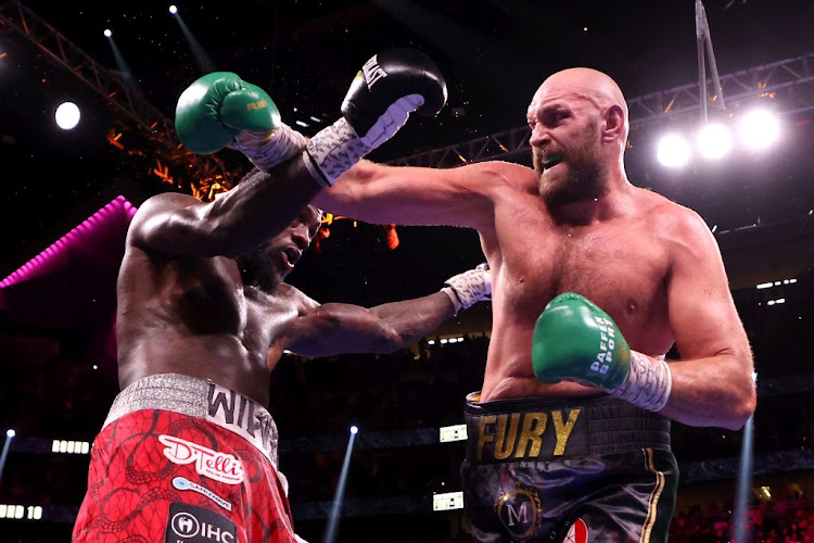 Tyson Fury (right) and Deontay Wilder exchange punches during their WBC heavyweight title fight at T-Mobile Arena on October 09, 2021 in Las Vegas, Nevada.