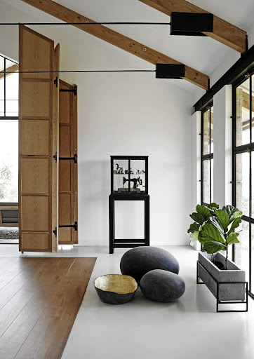 The bedroom is west-facing and opens onto a balcony overlooking a nearby grove of trees, so a folding timber screen helps control the harsh afternoon sun.