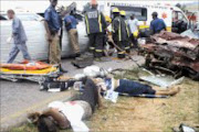 TARMAC TRAGEDY: On Christmas Eve a minibus taxi crashed and overturned after the driver of a car made a turn in front of it on Main Reef Road. some passengers were trapped and paramedics and metro police battled for hours with cutting torches. Pic. Mbuzeni Zulu. 26/12/06. © Sowetan.