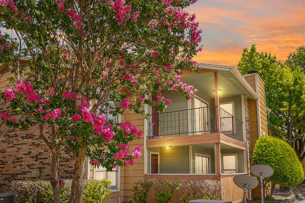 View of Bella Vista apartment building with balconies and patios, surrounding landscaping at dusk