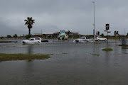 Motorists drive thorough flooded streets in Summerstrand.