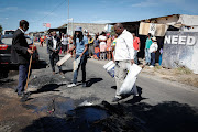 The distraught family of Mbodazwe Elvis Nyathi, who was killed and set alight on Wednesday night in Diepsloot, on Thursday cleaned the area where he was murdered.
