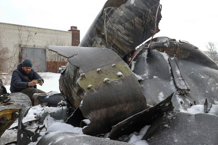 A man photographs parts of an unidentified missile, which Ukrainian authorities believe to be made in North Korea and was used in a strike in Kharkiv, amid Russia's attack on Ukraine, in Kharkiv, Ukraine January 6, 2024.