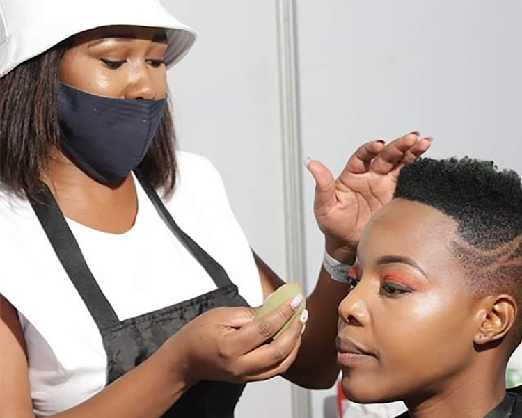 Amanda Nyoka works on the make-up of singer Nomcebo Zikode.