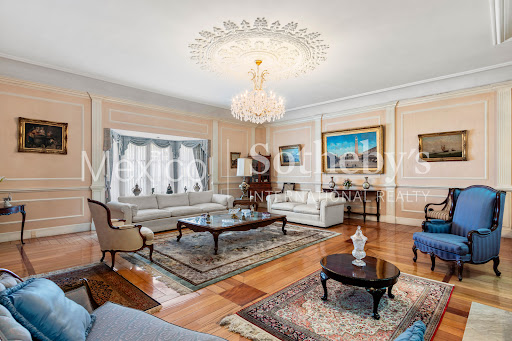 Elegant living room with two white sofas in this luxury property for sale in Mexico City ($2,062,438)