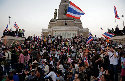 Thai anti-government protesters wave national flags as they occupy Victory Monument in downtown Bangkok on January 13, 2014. Tens of thousands of Thai opposition protesters occupied major streets in central Bangkok on January 13 in an attempted "shutdown" of the capital, escalating a campaign to unseat the embattled premier.