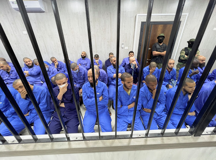 Suspects sit behind bars during a judgment sentence against 56 defendants accused of joining Islamic State group (ISIS) in the court in Misrata, Libya, May 29, 2023.