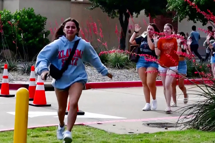 A girl runs as other shoppers leave with their hands up after police responded to a gunman who shot and killed eight people and wounded several others in Allen, Texas, the US, May 6 2023. Picture: REUTERS TV