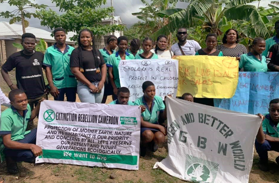 Rebels and school children hold signs in a lush landscape