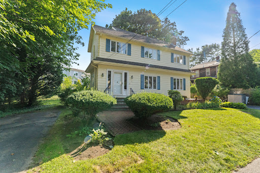 Yellow house with blue shutters and garden in this luxury property for sale in Marblehead ($960,000)