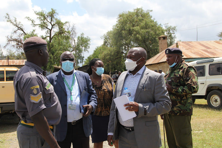 Laikipia East deputy county commissioner Patrick Muli (Right) consults with enforcement officers from Laikipia county government at the three-acre piece of land that is being contested by the county government and Kenha.