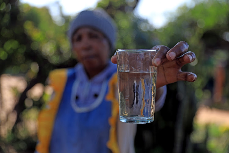 A resident of Hammanskraal shows the water that comes out of their taps.