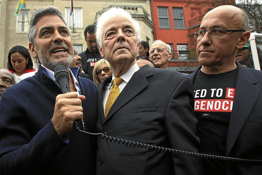 Clooney with his father Nick, centre, and activist Tom Andrews at a protest outside the Sudanese Embassy in Washington DC in 2012.