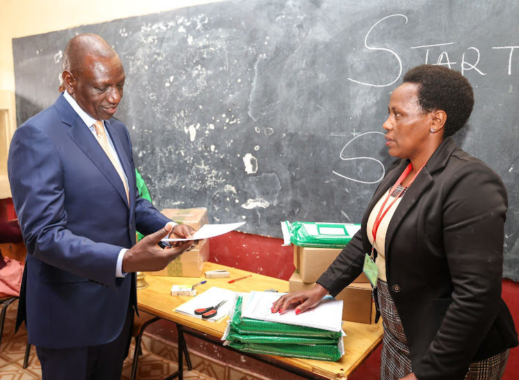 President William Ruto looking at KCPE papers at Kikuyu Township Primary School, Kiambu on October 31, 2023
