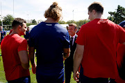 French president Emmanuel Macron meets with players including France's lock Bastien Chalureau (centre) during a meeting with the rugby team at their base camp's training pitch in Rueil-Malmaison, outside Paris on Monday. 